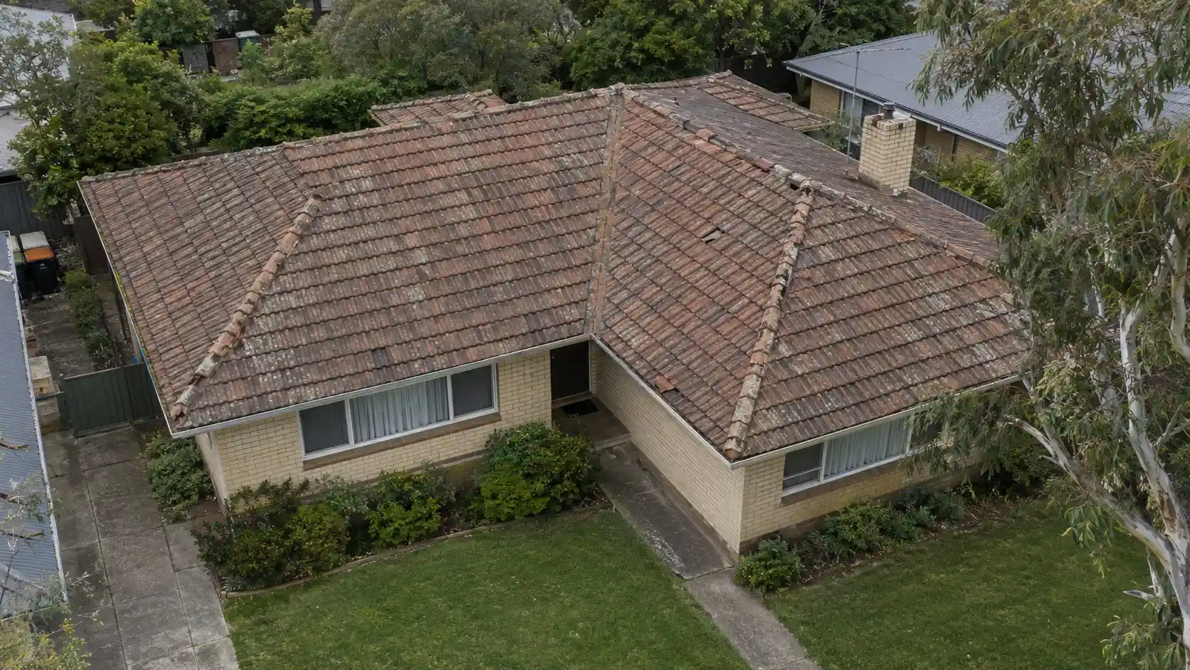Cracked mossy concrete tile roof